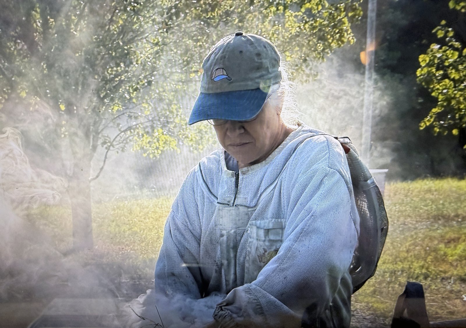 Kory at sunrise lighting a smoker before working a Frosty Meadow apiary